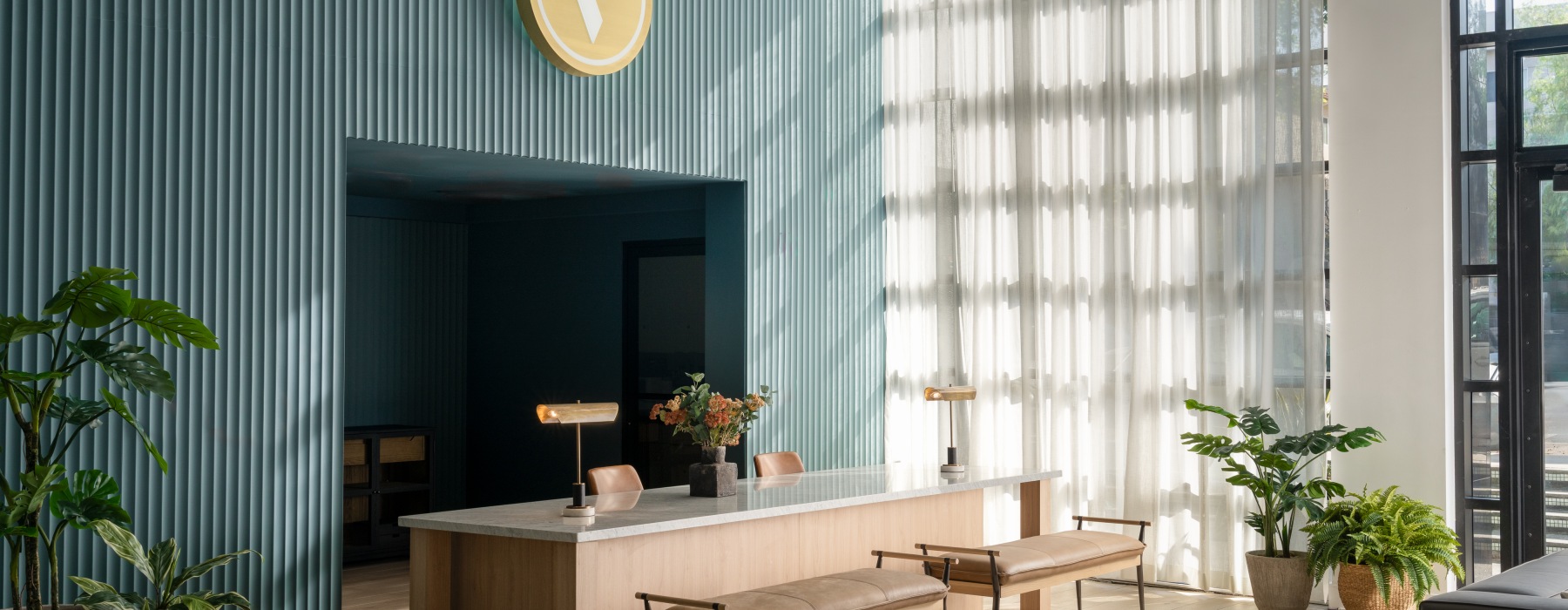 the front desk of a leasing office with a desk and benches