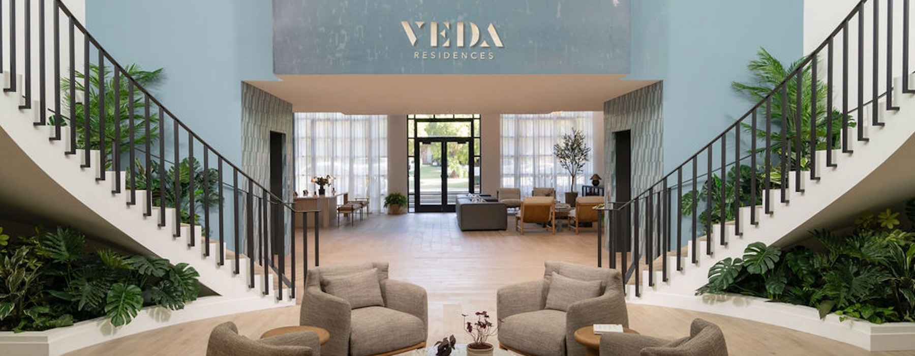 the entrance of a lobby with stairs and chairs