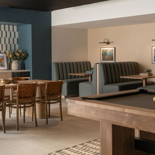 a clubroom with a tv, pool table, booths and chairs