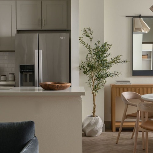 a kitchen and a living room with tables and chairs