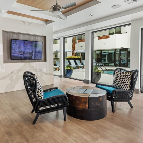 room with two chairs and a coffee table overlooking a pool