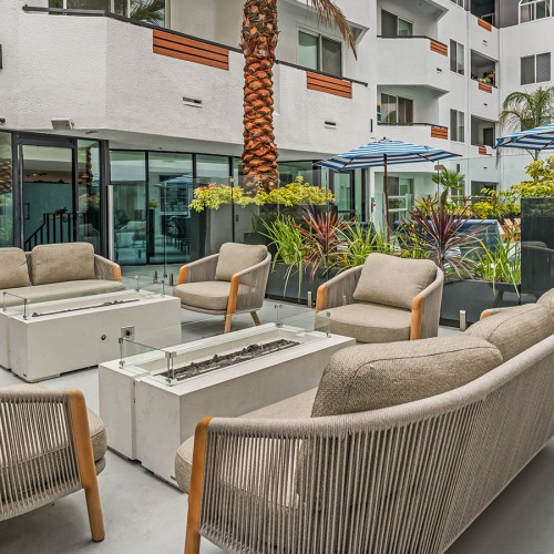 couch and chairs around a firepit in a courtyard